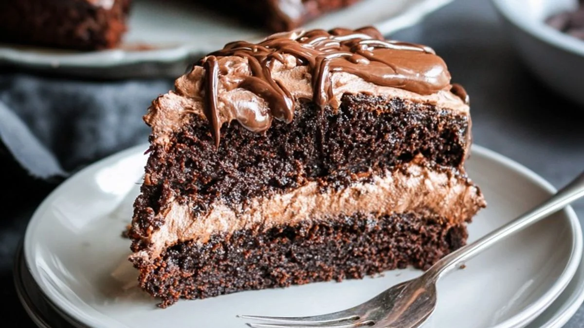 Chocolate Fudge Slice 2 A decadent Chocolate Fudge Slice drizzled with glossy ganache and garnished with mint on a wooden board