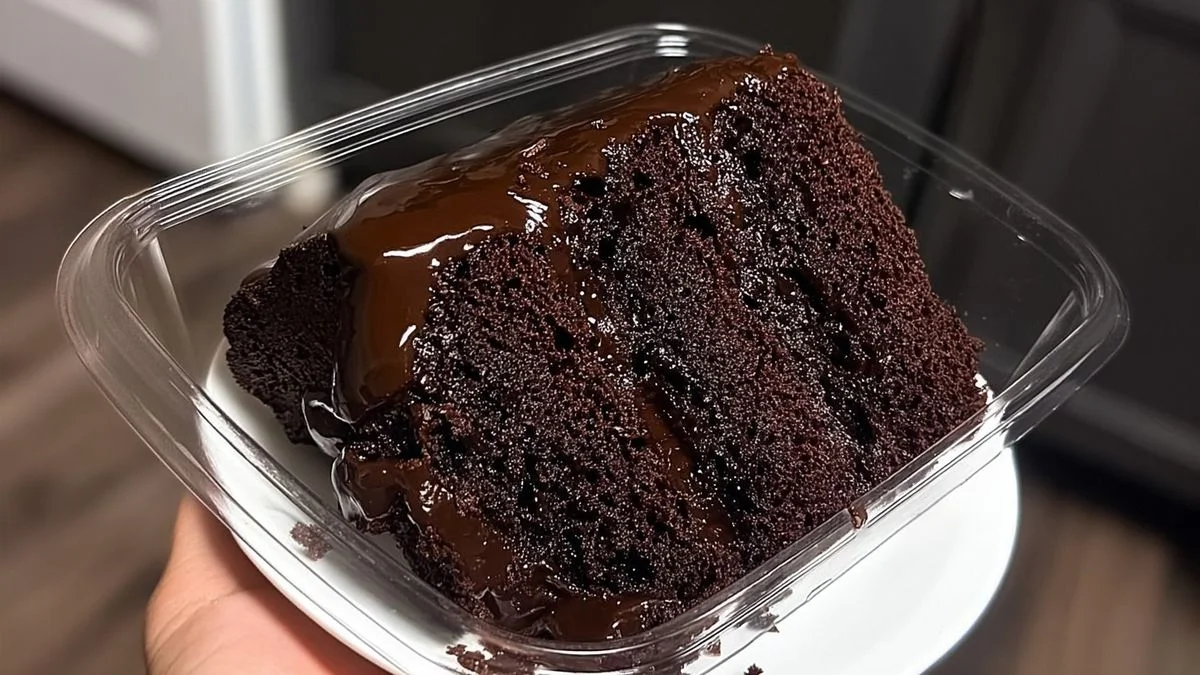 A moist chocolate cake with glossy ganache and fresh raspberries