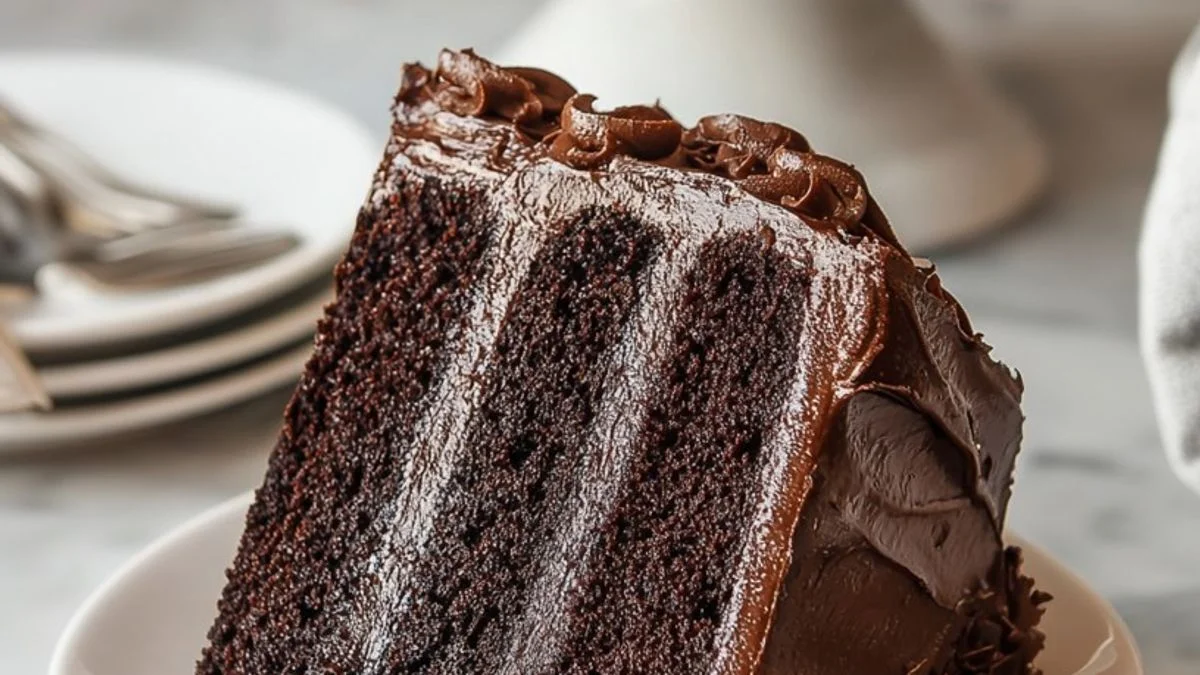 A decadent Rich Triple Chocolate Cake with three layers of chocolate sponge, silky ganache drips, and chocolate shavings.