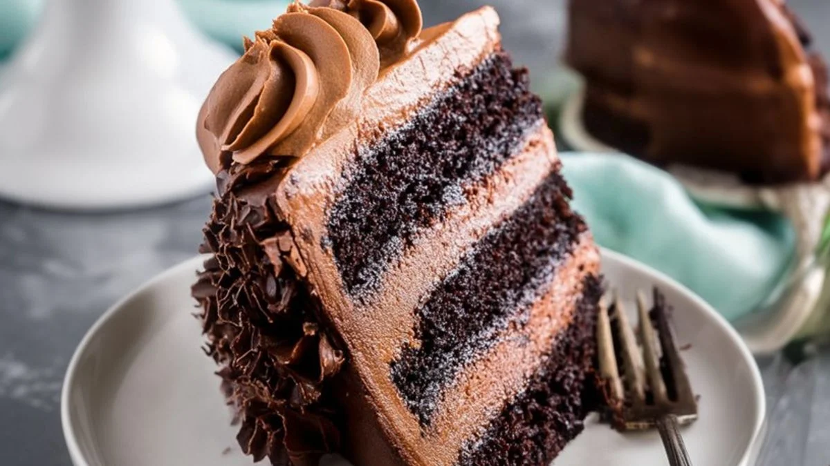 Close-up of a decadent Triple Chocolate Layer cake slice with three rich chocolate layers and ganache topping.