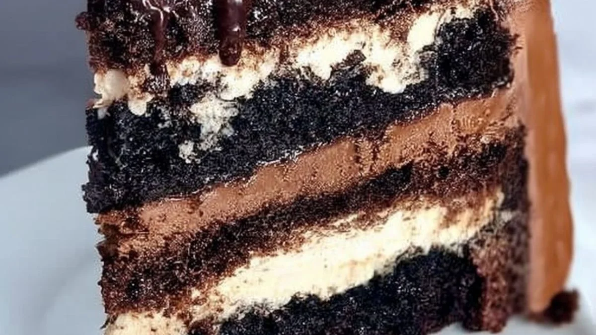 A slice of Triple Mocha Velvet Cake topped with mocha frosting, dark chocolate shavings, and coffee beans