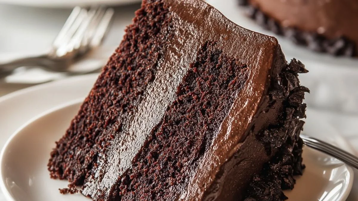 A close-up of a rich and gooey Ultimate Fudge Slice on a rustic wooden board garnished with fresh berries.