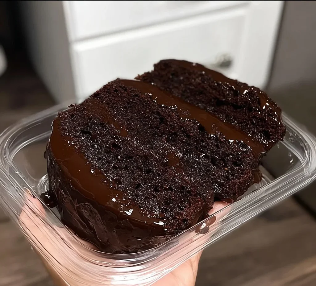 Ultimate moist chocolate slice with chocolate ganache and raspberries on a rustic plate