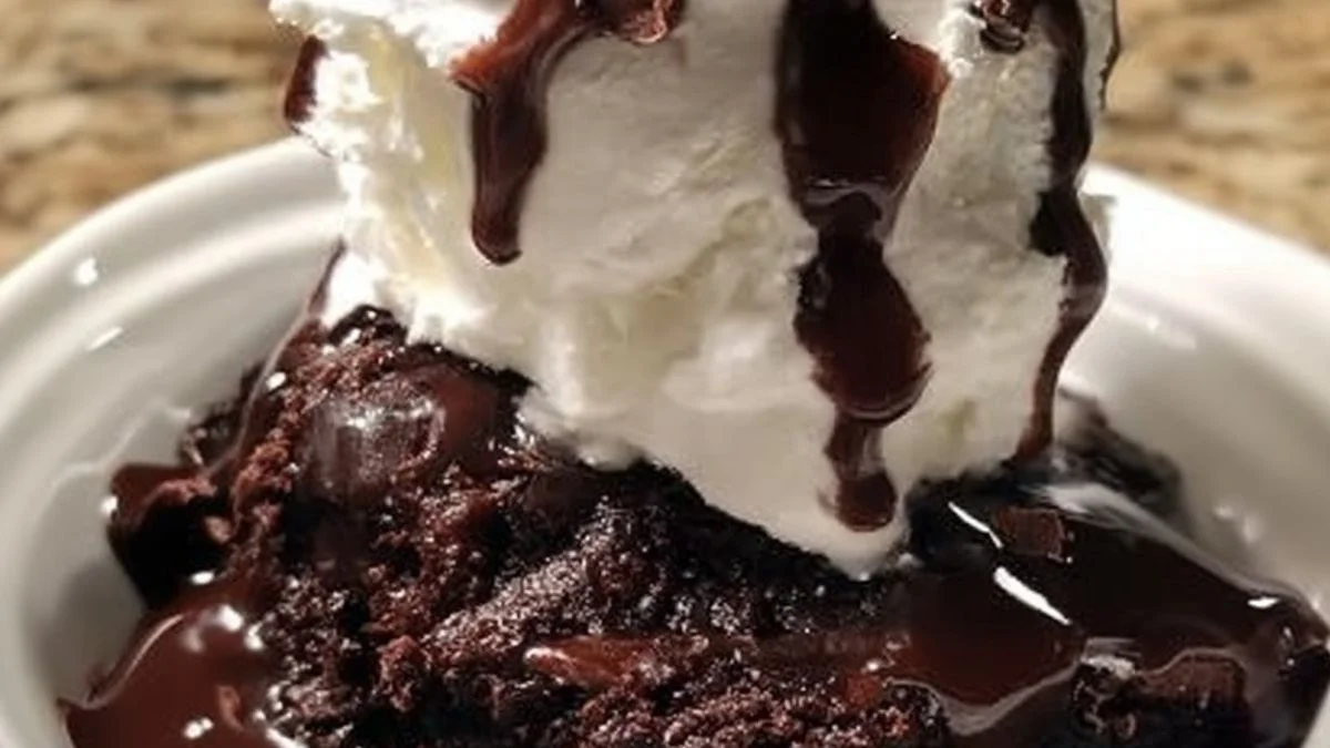 Chocolate Brownie Sundae 2 Close-up of a Chocolate Brownie Sundae in a glass bowl with melting vanilla ice cream, whipped cream, and a bright red cherry on top