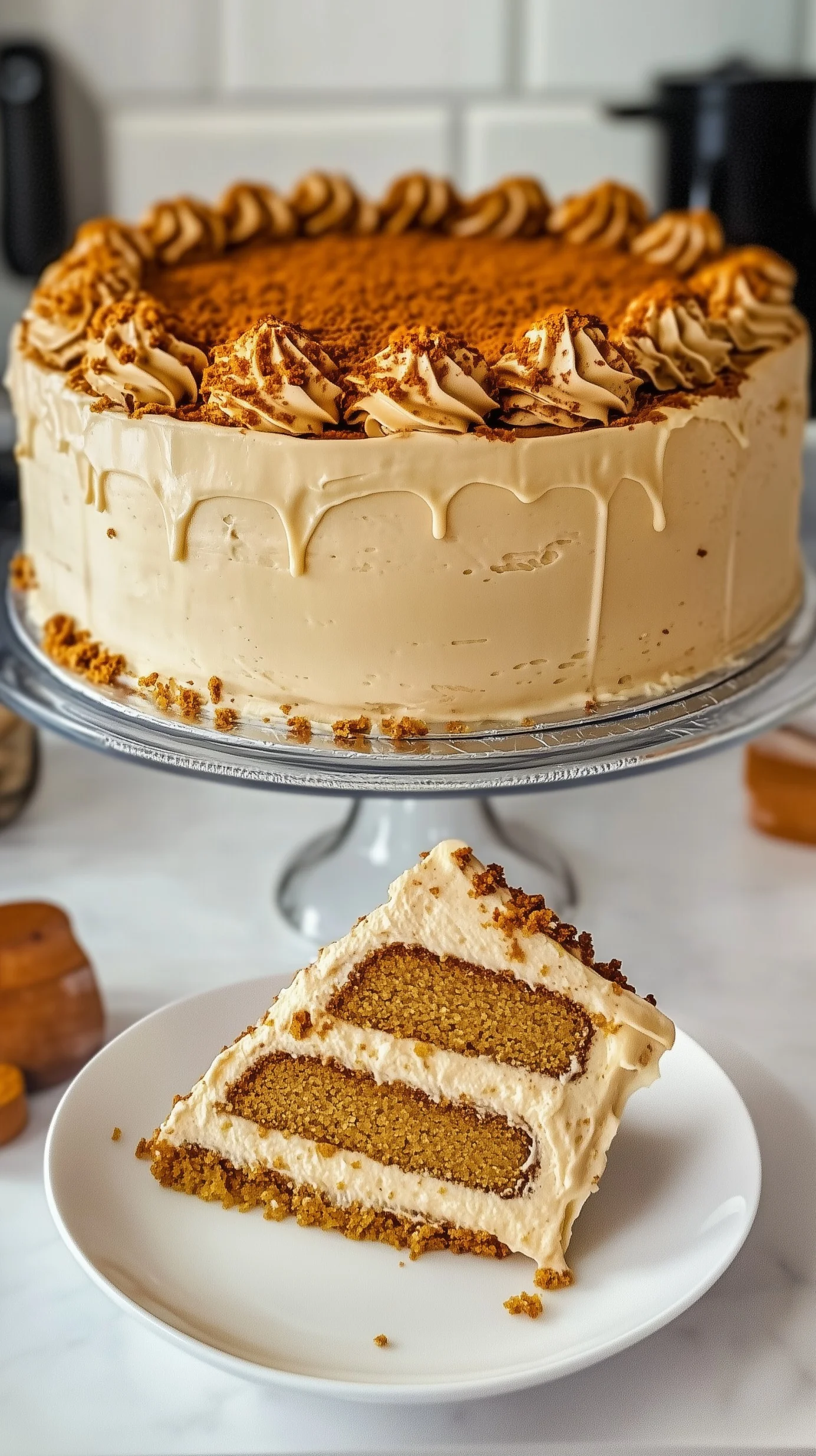 Multi-layered Biscoff cake with Biscoff buttercream, caramel drizzle, cookie crumbles, and caramel shards on a wooden board.