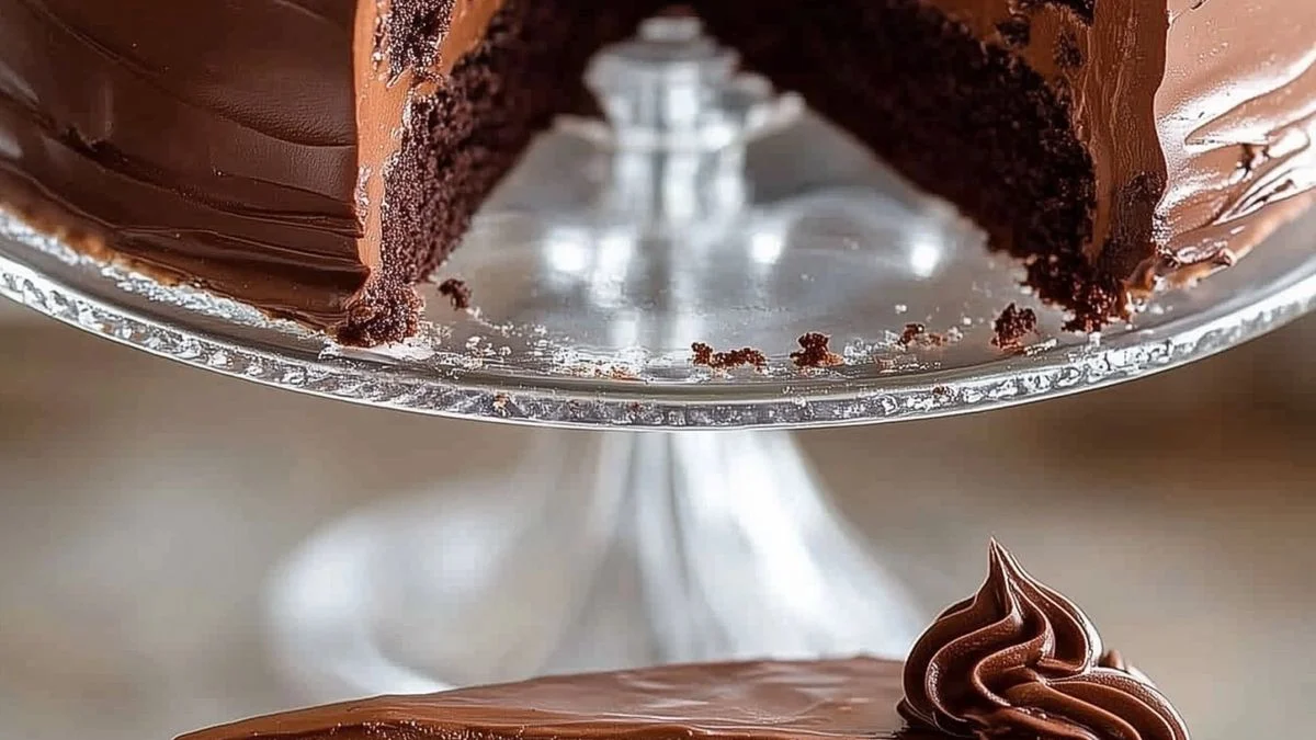 Three-layer Triple Chocolate Cake with glossy ganache and chocolate shavings on a rustic table