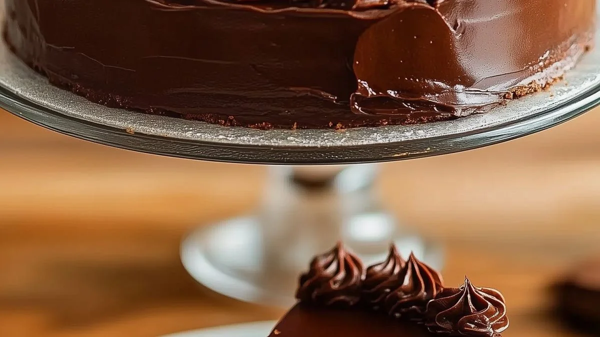 A decadent Triple-Layer Chocolate Ganache Cake with glossy ganache layers and chocolate shavings on a rustic wooden table.